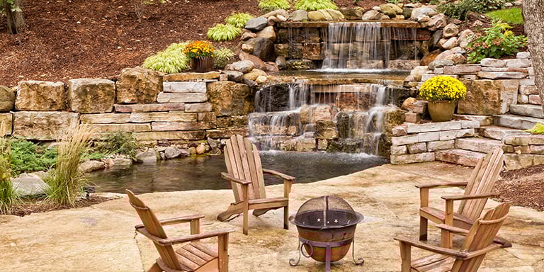 Backyard with rock wall, fountain, waterfall, fire pit and hardscaping