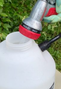 Filling a Chapin sprayer with water with a garden hose nozzle