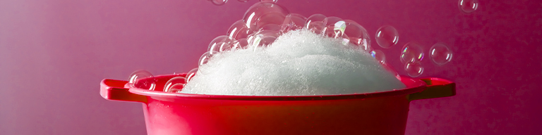 Soapy water in a red bucket with lots of bubbles