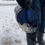 Chapin 8740A 64-ounce hand shaker spreader in use shaking salt on driveway