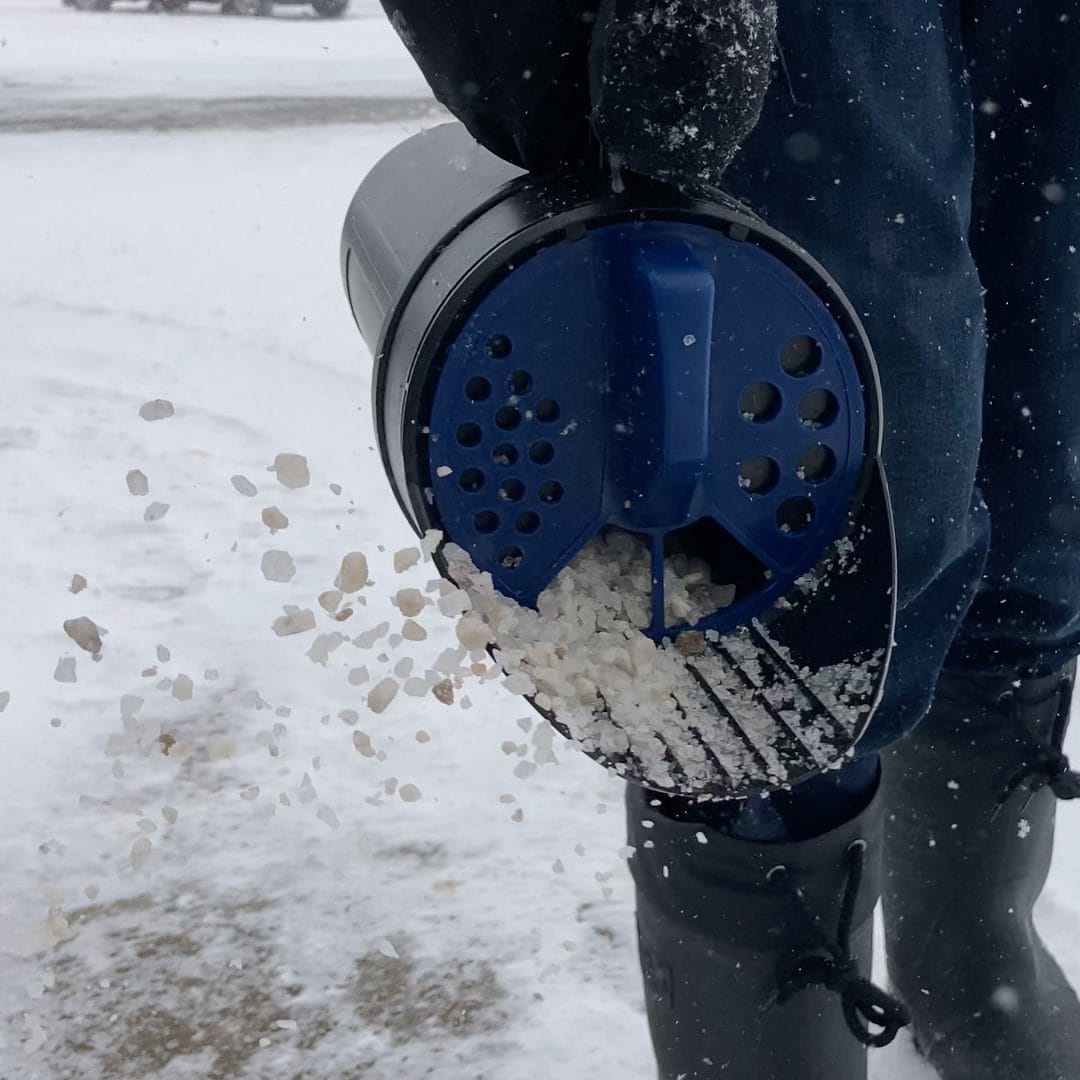8740a_use2 Chapin 8740A 64-ounce hand shaker spreader in use shaking salt on driveway