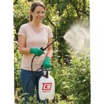 Woman spraying plants in a garden with a Chapin 20000 SureSpray garden sprayer