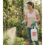 Woman spraying plants in a garden with a Chapin 20002 SureSpray garden sprayer